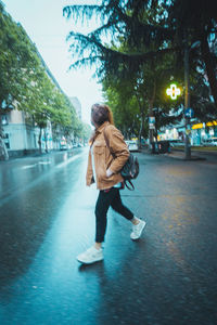 Woman walking on street in rain