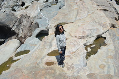 High angle view portrait of woman standing on rock