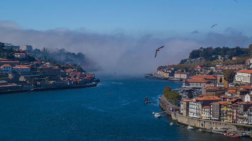 Panoramic view of sea and cityscape against sky