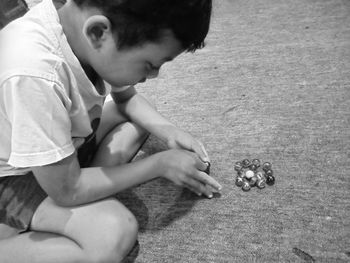 Little boy playing the traditional game of marbles