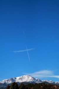 Scenic view of vapor trail against clear blue sky