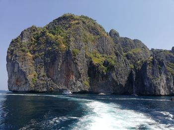 Scenic view of rocks in sea against clear sky