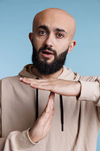 Low angle view of man standing against blue background