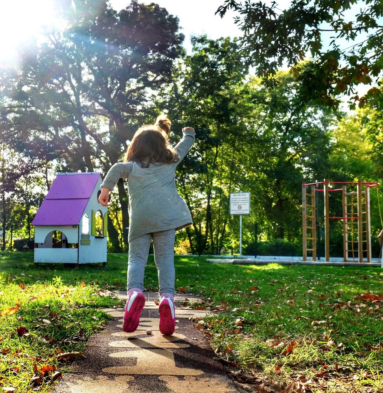 YOUNG WOMAN PLAYING IN PARK