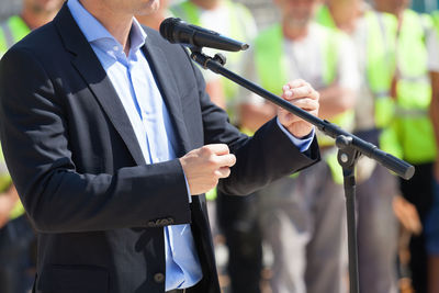 Midsection of businessman giving speech during press conference