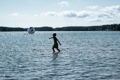 Full length of boy on lake against sky