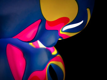 Close-up of multi colored light painting against black background