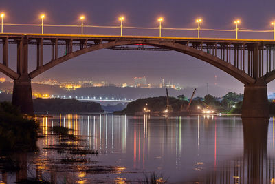 Night city bridge lighting. beautiful reflection of night lights on water surface. long exposure