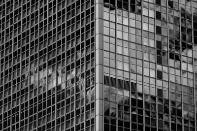 Full frame shot of glass windows of modern building with reflection