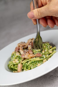 Cropped hand of person preparing food in plate