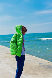 Side view of man standing at beach