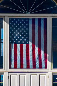 Close-up of flags against blue wall