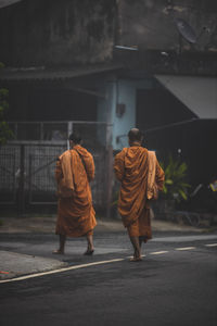 Rear view of people walking on road