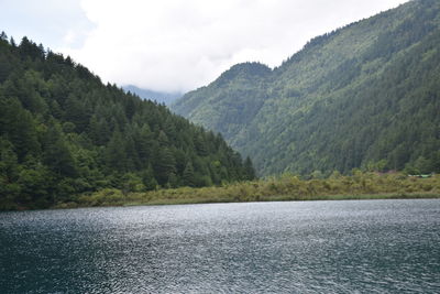 Scenic view of lake by mountains against sky