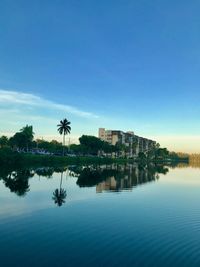 Reflection of building in lake against blue sky