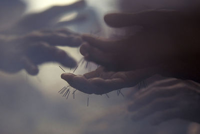 Cropped hands of people with nail piercing in smoke