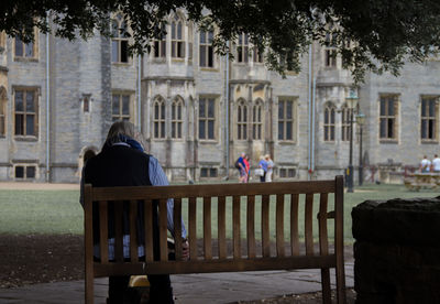 Rear view of people on chair outside building