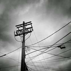 Low angle view of electricity pylon against sky