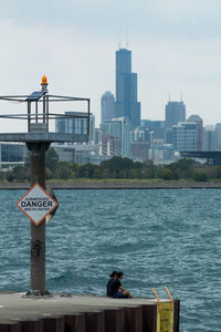 View of city by sea against sky