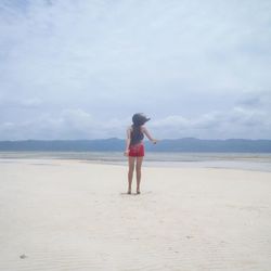 Rear view of woman standing on beach