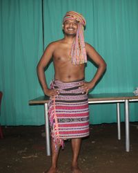 Portrait of a smiling young woman standing against wall