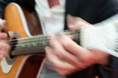 Midsection of woman playing guitar