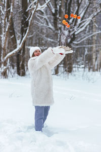 Rear view of woman standing on snow covered field