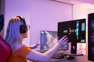 Rear view of woman using mobile phone in office