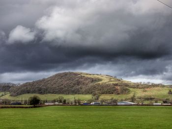 Scenic view of grassy field against cloudy sky