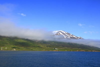 Scenic view of snowcapped mountain against blue sky