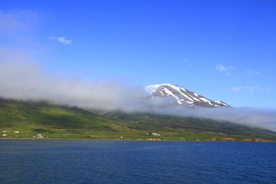 Scenic view of snowcapped mountain against blue sky