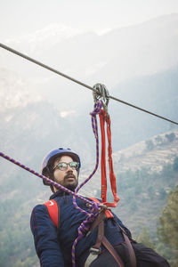 Portrait of man holding umbrella against mountain
