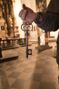 Close-up of person holding umbrella on floor