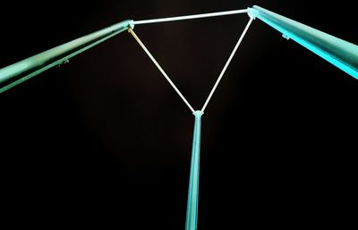 Low angle view of basketball hoop against black background