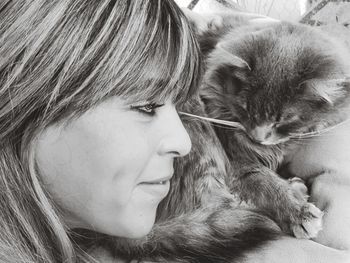 Close-up of smiling woman with cat at home