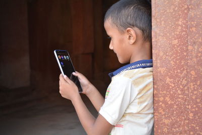 Midsection of boy using mobile phone