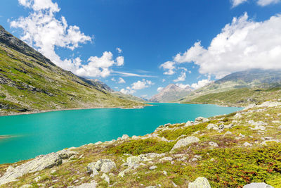 Scenic view of lake and mountains against blue sky