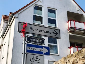 Low angle view of road sign against built structure