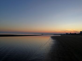 Scenic view of beach against clear sky during sunset