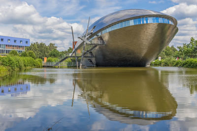 Built structure by lake against sky