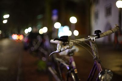 Close-up of bicycle on street at night