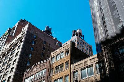 Low angle view of buildings against clear blue sky