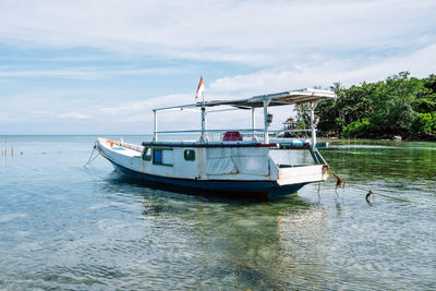 Boat moored in sea against sky