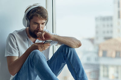 Side view of young man using mobile phone