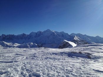 Scenic view of snow covered landscape against clear blue sky