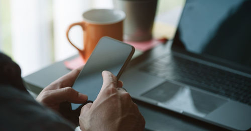 Cropped hands of man using mobile phone