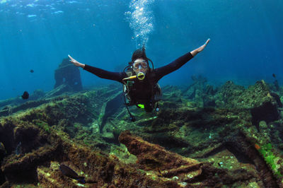 A woman doing scuba diving near a shipwreck