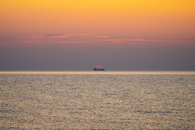 Scenic view of sea against orange sky