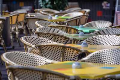 High angle view of empty chairs and tables at sidewalk cafe