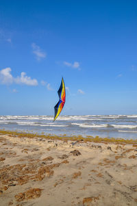 Umbrella on beach against blue sky